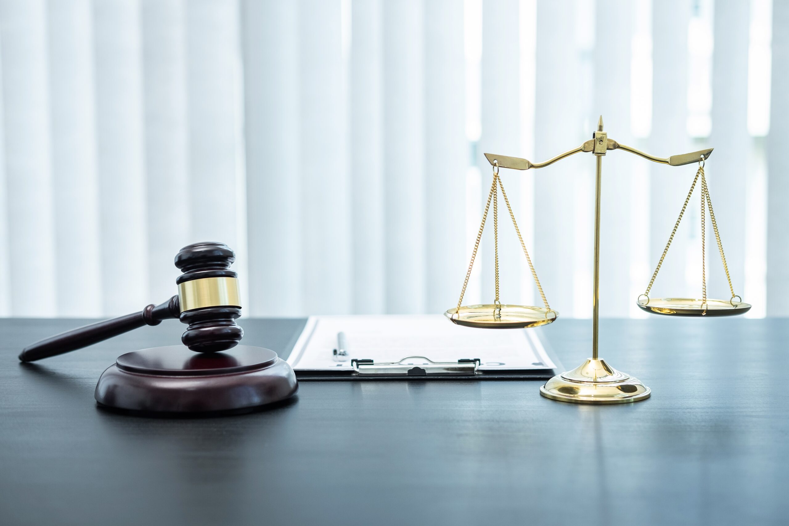 Judge gavel with Justice at law firm in background with legal case document contract, law and justice, attorney, lawsuit.