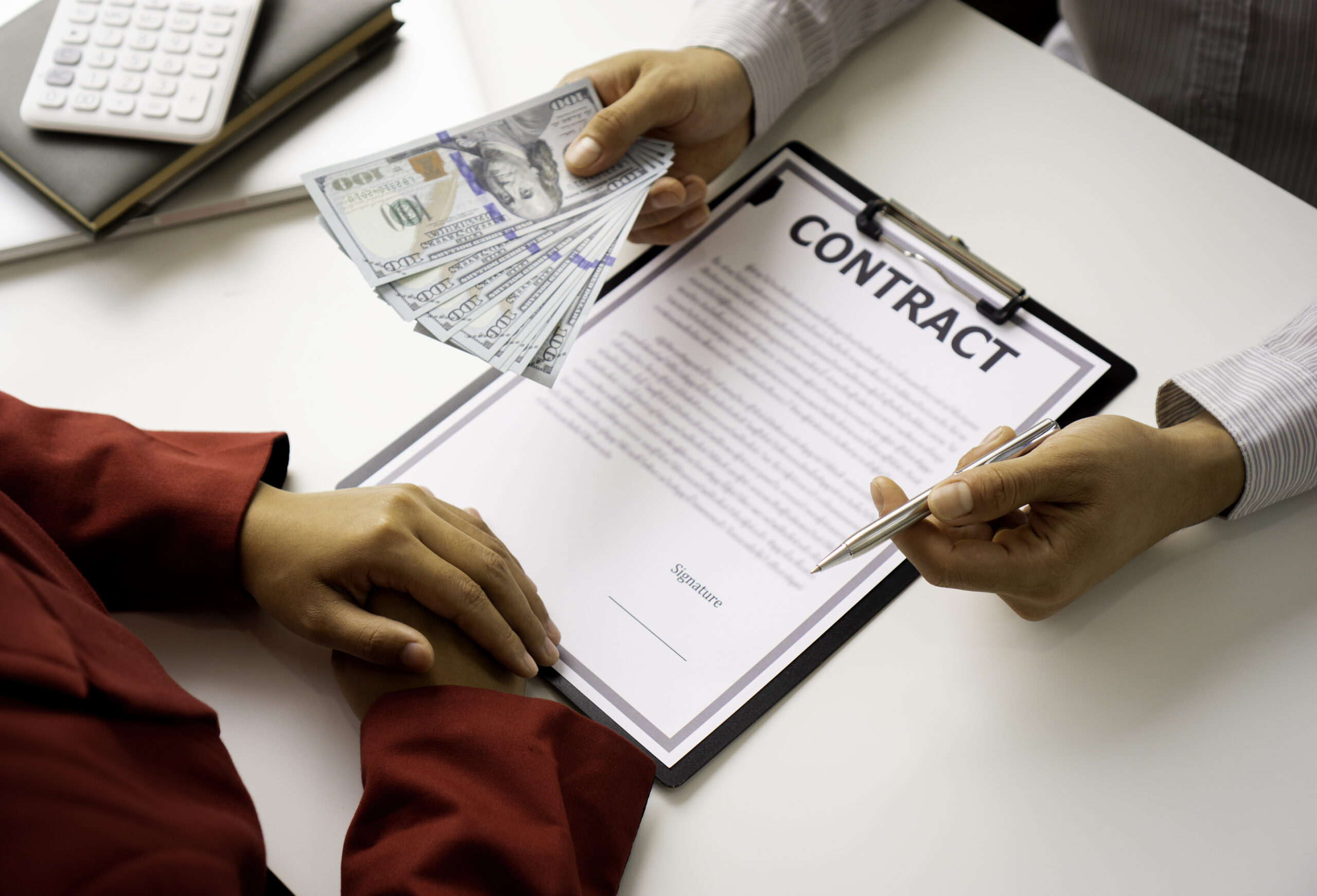 bribery and corruption concept, businessmen offer bribes to business women to sign and manage real estate contracts smoothly.