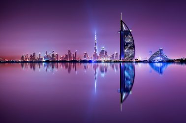 Detail of skyscraper reflection. Beautiful skyline scene in Dubai. Multiple highest buildings during night. The Palm island, United Arab Emirates.