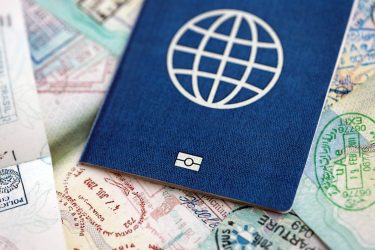 Many open passport pages with lots of visas and entrance stamps from various countries passport control. Concept of travel and tourism worldwide