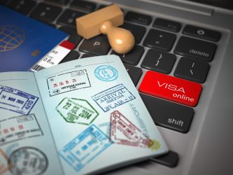 Visa online application concept. Open passport with visa stamps with airline boarding pass tickets and stamper on the computer keyboard. 3d illustration